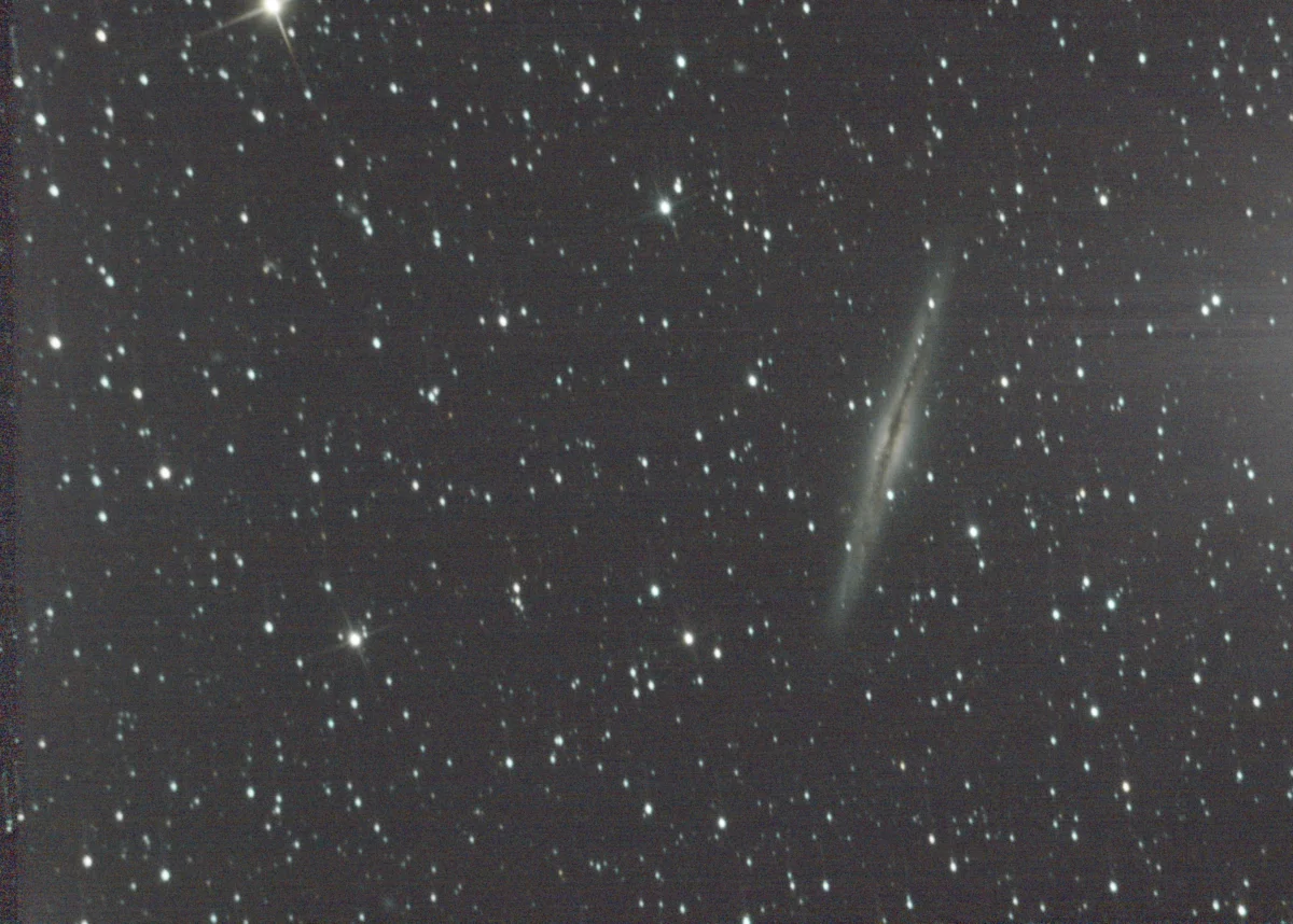 The edge-on spiral galaxy NGC 891 in Andromeda, a thin needle of starlight crossed by a dark central dust lane